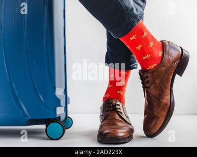 Stilvolle Koffer, Beine der Männer und helle Socken Stockfoto