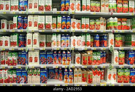 Breite Palette von Säften in den Regalen der Supermärkte. Natürliche Säfte in den Regalen der Shop. Verschiedene Fruchtsäfte in den Regalen im Supermarkt. Verschiedene Saft in pap Stockfoto