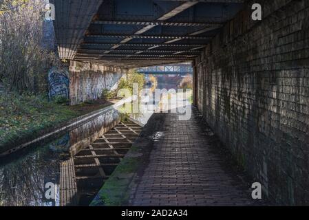 Graffiti malte auf eine Mauer durch eine Brücke über die Worcester und Birmingham Canal in Selly Oak, Birmingham, Großbritannien Stockfoto