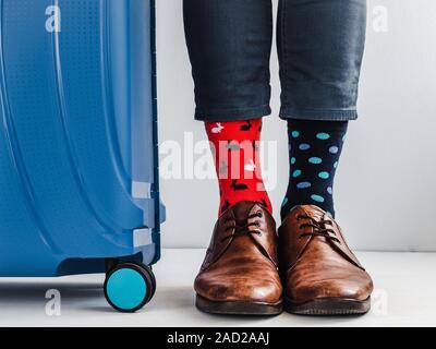 Stilvolle Koffer, Beine der Männer und helle Socken Stockfoto