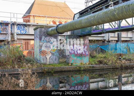 Graffiti malte auf eine Mauer durch eine Brücke über die Worcester und Birmingham Canal in Selly Oak, Birmingham, Großbritannien Stockfoto