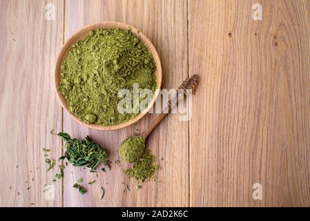 Hanf Mehl in Houten, Pulver in Löffel, Cannabis Blätter auf dem Hintergrund der Holzplatte Stockfoto