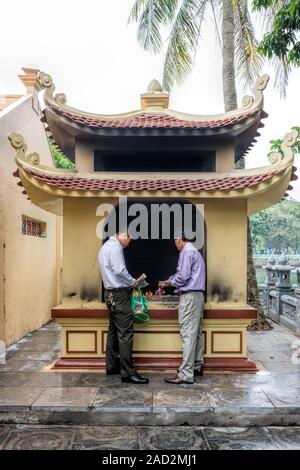 Tran Quoc Pagode Hanoi, zwei Männer Brennen von gefälschtem Geld als Angebot an Buddha Stockfoto