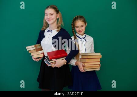 Zwei Mädchen von Schülerinnen mit Büchern steht am grünen Brett Studie im Klassenzimmer Stockfoto
