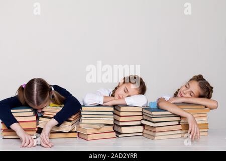 Drei Mädchen der Schule Mädchen mit Bücher schlafen an einem Schreibtisch im Klassenzimmer Stockfoto