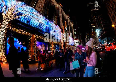 Käufer an der Weihnachten windows von Saks Fifth Avenue an der Fifth Avenue in Midtown Manhattan in New York am Dienstag, 26. November 2019. Dieses Jahr Saks Fifth Avenue hat mit Disney für "Frozen 2 "themed Windows eingegangen. (© Richard B. Levine) Stockfoto