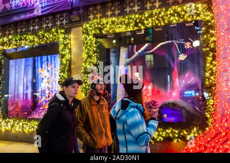 Käufer an der Weihnachten windows von Saks Fifth Avenue an der Fifth Avenue in Midtown Manhattan in New York am Dienstag, 26. November 2019. Dieses Jahr Saks Fifth Avenue hat mit Disney für "Frozen 2 "themed Windows eingegangen. (© Richard B. Levine) Stockfoto