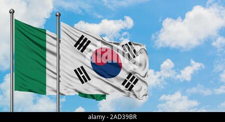 Nigeria und Südkorea Flagge im Wind gegen Weiße bewölkt blauer Himmel zusammen. Diplomatie Konzept, internationale Beziehungen. Stockfoto