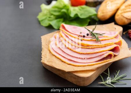 Close up frischer Hum Fleisch für Sandwiches, dunklen Kammer mit Gemüse für den Hintergrund. Stockfoto