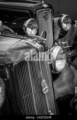 Schwarz-Weiß-Nahaufnahme von klassischen, britischen Oldtimern Morris Twelve & Austin Six, geparkt um 1940s Uhr, Kriegsereignis des Zweiten Weltkriegs, Sommer in Großbritannien. Stockfoto