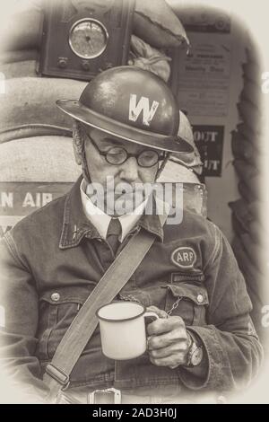 Schwarz-weiß 1940er Mann als Kriegszeit ARP Warden in W Helm (Luftangriff Vorsorge), Severn Valley Railway, UK 1940er WWII Ereignis, durch Luftschutzkeller. Stockfoto