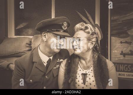 Vintage Sepia Nahaufnahme 1940er verliebten Paar, sitzen am Heritage Bahnhof Abschied sagen; Severn Valley Railway 1940er Veranstaltung. Wir werden uns wieder treffen. Stockfoto