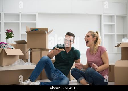 Junges Paar haben eine Pizza Mittagspause auf dem Boden Stockfoto