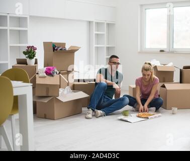 Junges Paar haben eine Pizza Mittagspause auf dem Boden Stockfoto