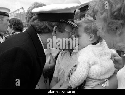 AJAXNETPHOTO. 19. JUNI 1982. Portsmouth, England. - Falklandinseln Veteran - ein Offizier DER SHEFFIELD Klasse (Typ 42/1 und 2) Zerstörer HMS Glasgow erhält ein herzliches Willkommen von seiner jungen Familie, wenn seine Bombe beschädigte Schiff NACH PORTSMOUTH IN 1982 ZURÜCK. Foto: Jonathan Eastland/AJAX. REF: HD NA GLAS 82 22. Stockfoto