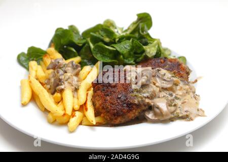 Frikadellen mit Fingerförmigen Kartoffelklöße, Feldsalat und Pilzsauce Stockfoto