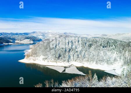 Winter in Kroatien. Panorama der Lokvarsko See und Wälder unter Schnee in Gorski kotar und Risnjak Berg im Hintergrund von Drone. Stockfoto