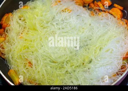 Glasnudeln Zellophan Nahaufnahme in der Pfanne. Hintergrund Nudeln kochen, braten Gemüse Stockfoto