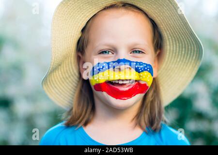 Kleines Mädchen Lachen in Strohhut mit bemaltem Gesicht Spaß. Outdoor portrait Stockfoto