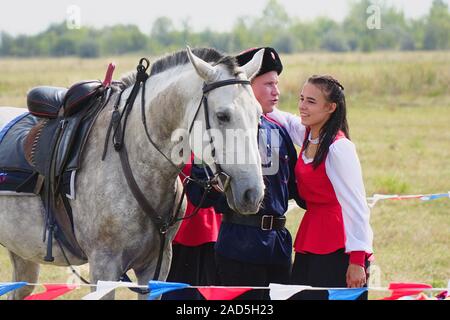 Samara, Russland - Oktober 07, 2019: Junge Kosak Kosak und Mädchen in Trachten steht neben dem Pferd. Das Mädchen sagt Auf Wiedersehen zu den Cossac Stockfoto