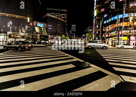 Tokyo, Japan - 14. Januar 2010: Autos Überqueren der Straße im Herzen von Ginza in Tokio. Ginza Kreuzung bei Nacht. Verschwommene Bewegung. Stockfoto