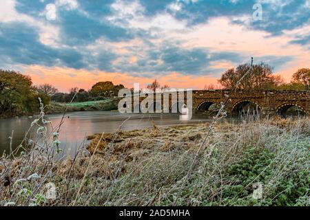 Sonnenaufgang über weiße Mühle Brücke am River Stour Stockfoto