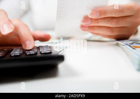 Einsparungen, Finanzen, Wirtschaft und Wohnkonzept - Nahaufnahme von Händen mit Taschenrechner Geldzählen und Notizen zu Hause Stockfoto