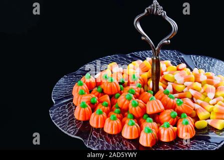 Halloween Kürbis mais Form und geformten Süßigkeiten serviert auf einem goldfarbenen Antike anrichten. Kopieren Sie Platz in schwarzen Hintergrund. Stockfoto