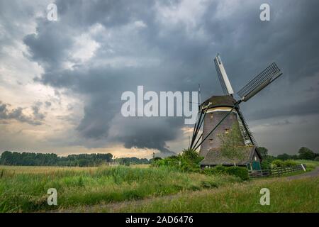 Traditionelle Windmühle in Holland unter einem stürmischen Himmel Stockfoto