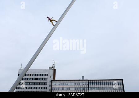 Kassel, Deutschland. 01 Dez, 2019. Die Skulptur "Der Weg zum Himmel" (documenta 9, 1992) des amerikanischen Künstlers Jonathan Borofsky scheint vor dem Kulturbahnhof über die schlichte Wolkenkratzer aus den 1970er Jahren steigen. Quelle: Uwe Zucchi/dpa/Alamy leben Nachrichten Stockfoto