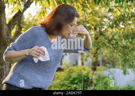 Saisonale Allergien, Frau mit der Nase wischen, Niesen, wischen Nase outdoor Stockfoto