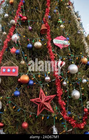 Christbaumschmuck auf einer großen Gemeinschaft Baum. Stockfoto