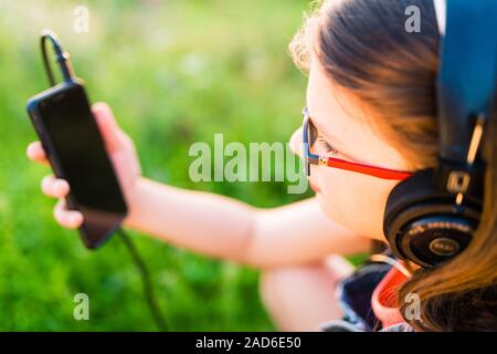 Jugendlich Mädchen Musik Hören mit Ihren Kopfhörern outdoor Stockfoto
