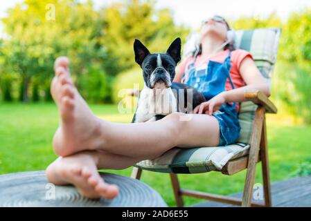 Hund und junges Mädchen im Garten ausruhen Stockfoto