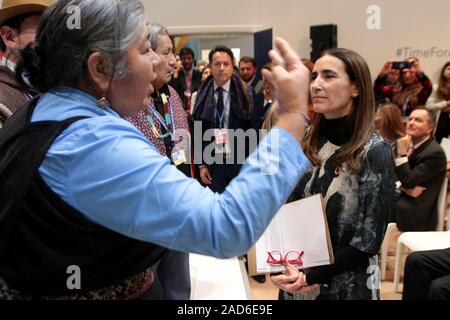 Madrid, Spanien. 3. Dezember, 2019. Chilenischen Minister für Umwelt, Carolina Schmidt, Präsident der 2019 Konferenz der Vereinten Nationen über Klimaänderungen (COP 25), ist von den chilenischen Ureinwohner vom Rat der Völker und der Atacameños vor seinen Präsidenten Sergio Luis Cubillos, während der Einweihung des Landes Platz in den Einrichtungen der COP 25 in Madrid, Spanien konfrontiert. Quelle: dpa Picture alliance/Alamy leben Nachrichten Stockfoto