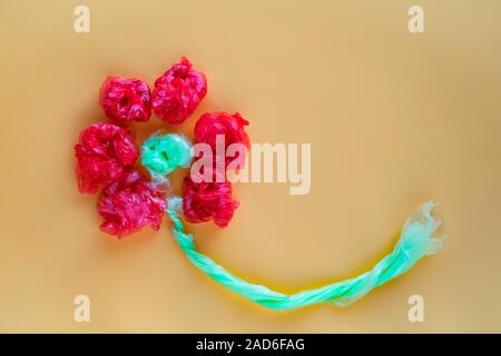 Blume aus rollten bunte Plastiktüten. Recycling und Abfall Konzept zu reduzieren. Ansicht von oben. Stockfoto