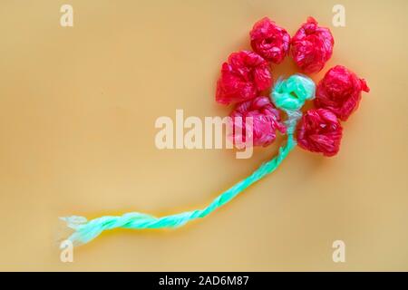 Blume aus rollten bunte Plastiktüten. Recycling und Abfall Konzept zu reduzieren. Ansicht von oben. Stockfoto