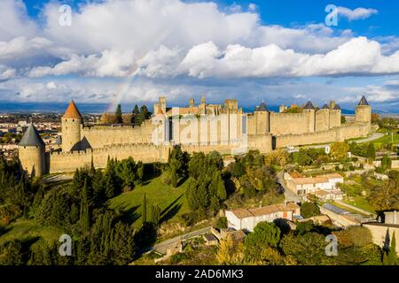 Regenbogen über Cite de Carcassonne, einer mittelalterlichen Zitadelle auf einem Hügel in der französischen Stadt Carcassonne, gestärkt durch zwei Burgmauern. Aude, Royal, Franc Stockfoto