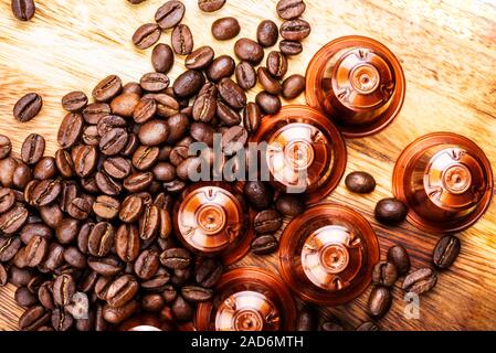 Espresso Kaffee Kapseln oder Hülsen und Kaffeebohnen auf Holz rustikale Hintergrund, Ansicht von oben Stockfoto
