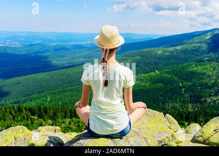 Young Travel Mädchen sitzen auf dem Rock Mountain, entspannend Stockfoto