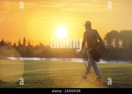 Stattlich im Nahen und Mittleren Osten Golfspieler Tragetasche und zu Fuß zum nächsten Loch Stockfoto