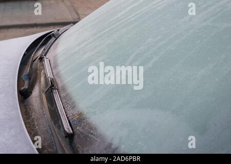 Gefrorene auto Windschutzscheibe mit Eis und Schnee an einem Wintertag abgedeckt. Nahaufnahme. In der Nähe des gefrorenen Windschutzscheibe und Scheibenwischer im Winter Stockfoto