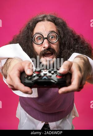 Porträt eines lustigen, skurrilen nerd Holding ein Gamepad Stockfoto