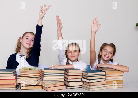 Drei Mädchen der Schule Mädchen mit Bücher für Studium sitzen am Schreibtisch im Klassenzimmer Stockfoto