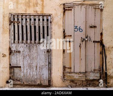 Heruntergekommen und verschlissen Doppeltür Eingang Nummer 36 mit einer Kette und einem Vorhängeschloss auf ein Gebäude in Valletta, Malta. Stockfoto