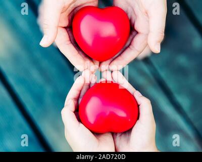 Herz in der Hand auf grauem Hintergrund Stockfoto