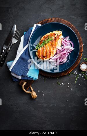 Saftig gegrillte Hähnchen Fleisch, Filet mit frischen marinierten Zwiebel an der Platte. Schwarzer Hintergrund, Ansicht von oben Stockfoto