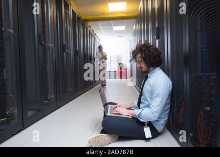 Team von jungen Technikern zusammen, die auf Servern Stockfoto