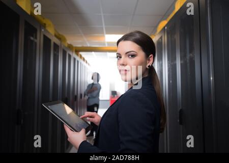 Ingenieurin arbeitet an einem Tablet-PC im Server Raum Stockfoto