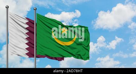 Katar und Mauretanien Flagge im Wind gegen Weiße bewölkt blauer Himmel zusammen. Diplomatie Konzept, internationale Beziehungen. Stockfoto